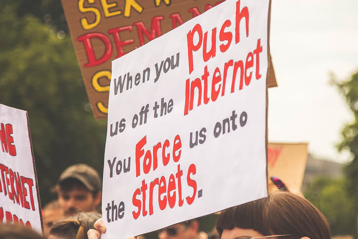 sex worker holding sign push us off internet force us into streets