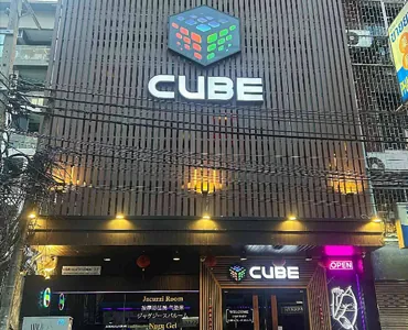 the exterior of Cube Nuru Massage in Bangkok with a large neon sign